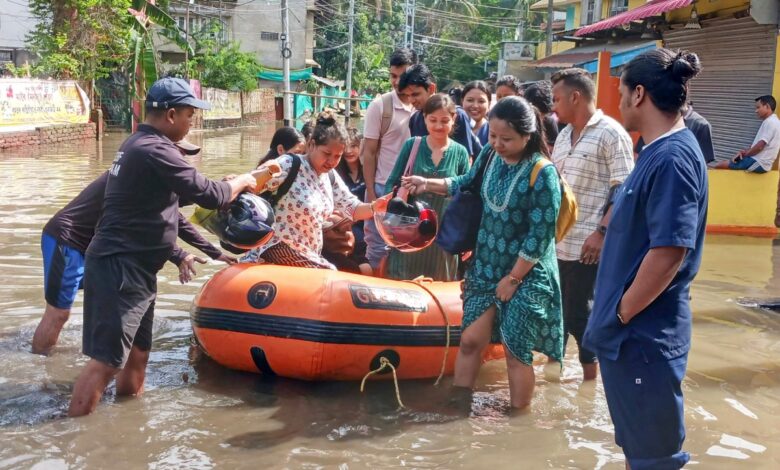 Nagaon: People walk through a flooded area following rains, at Kampur, in Nagaon district, Assam, Thursday, June 20, 2024. (PTI Photo)