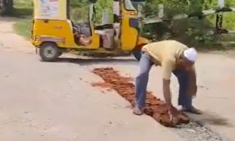 Auto driver fixes potholes with bricks and mud