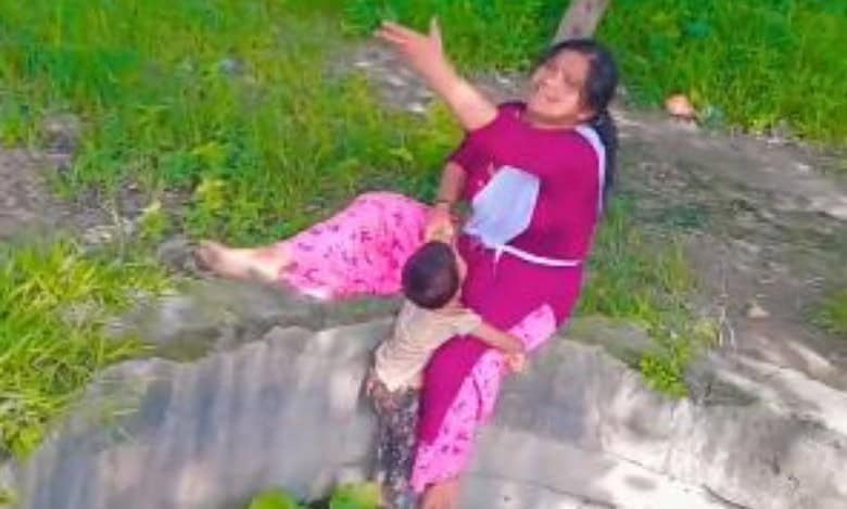 Video: Boy clings to mother’s leg as she sits on a well to record reel