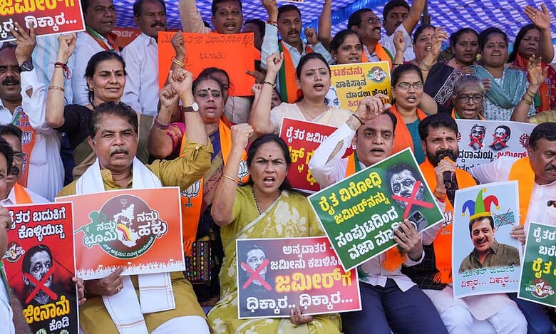 A BJP worker holds a placard during a protest against the Congress government in Karnataka over the Waqf land issue, in Bengaluru, Friday, Nov. 22, 2024. (PTI Photo