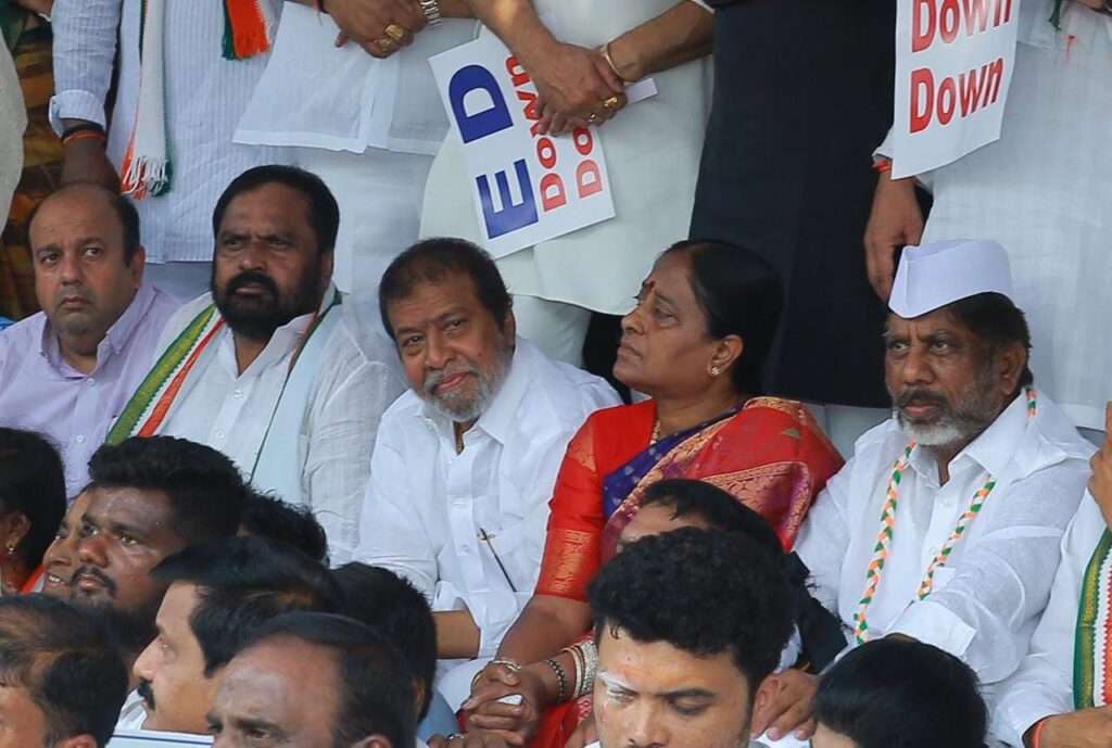 Telangana Congress leaders sitting in protest outside the Enforcement Directorate (ED) office in Hyderabad, holding placards and raising slogans.