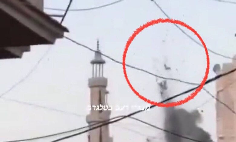 A screengrab from a viral video reportedly showing the aftermath of an Israeli missile strike in Gaza. The image features a mosque in the background, with a red circle highlighting what appears to be bodies being thrown into the air due to the explosion. Smoke is visible rising from the impact site, and electrical wires crisscross the foreground.