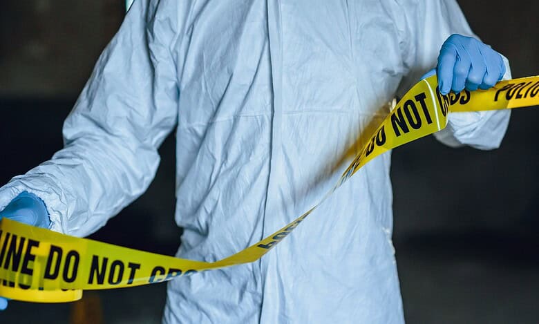 Representational Image of man putting up the crime scene tape