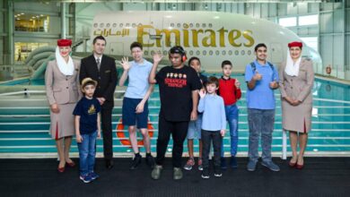 Children and Emirates staff pose in front of an A380 mock-up at the airline’s training facility.