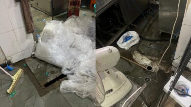 Two images show a cluttered industrial space, likely a kitchen or utility room. The left image has a tiled floor with plastic bags, blue bottle caps, and a broom against a wall. A large pile of plastic bags is near a drain. The right image features a pedestal fan on the floor among more plastic bags and debris. Exposed pipes, cables, and a water bottle are near stainless steel equipment. The area looks untidy, with water leakage and poor maintenance, indicating a need for cleaning and organization at the food production units in Hyderabad