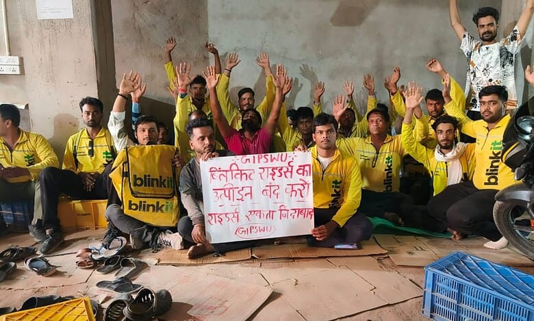 BlinkIt workers protest for fair pay holding a banner