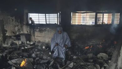 Palestinians inspect the rubble and debris at Yaffa school in Gaza City following an Israeli airstrike on April 23, 2025. The school building appears heavily damaged, with shattered concrete and twisted metal, as residents assess the destruction.