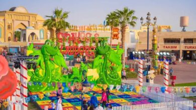 Colourful Snakes and Ladders-themed play area at Global Village Dubai with giant green snake figures, vibrant game board, and visitors enjoying family-friendly activities.