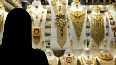 Woman in abaya looking at gold jewellery display in Dubai shop window