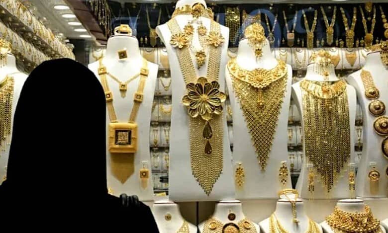 Woman in abaya looking at gold jewellery display in Dubai shop window