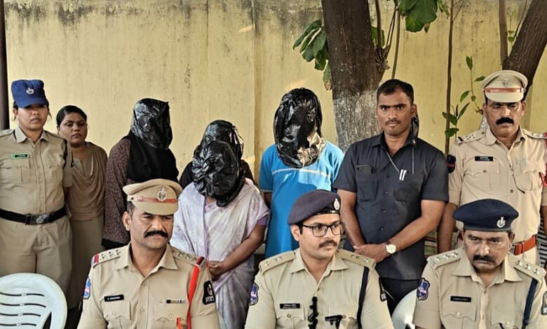 Chandrayangutta police present five arrested suspects involved in a child trafficking racket during a press briefing. The accused, with faces covered in black plastic, are surrounded by uniformed police officers.