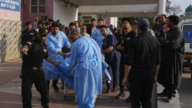 Paramedics and security personnel rush an injured individual into a hospital in Anantnag following the Pahalgam terror attack, amid a crowd of concerned onlookers.