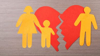 A cutout broken heart with a mother holding a child on one side and a father on the other, symbolizing a family split.