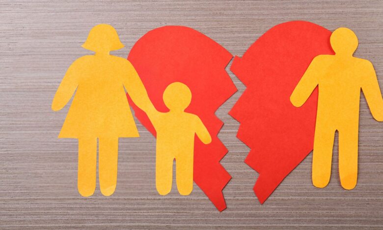 A cutout broken heart with a mother holding a child on one side and a father on the other, symbolizing a family split.