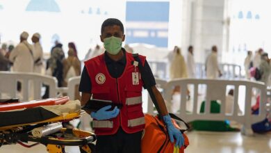 Saudi Red Crescent medic with stretcher and emergency bag at Grand Mosque.