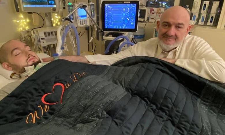 Saudi 'Sleeping Prince' Al-Waleed bin Khaled lies in a hospital bed with medical equipment around him, as his father sits beside him offering silent support.