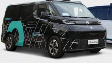 Self-driving taxi by WeRide, a black autonomous vehicle with futuristic hexagonal patterns, showcased with 'Robotaxi' branding. The vehicle, designed for urban smart mobility, features advanced sensors on its roof for autonomous navigation.