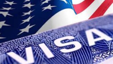 Close-up of a United States visa document with the American flag in the background, symbolising US immigration or travel authorisation.