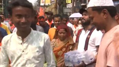 A Ram Navami devotee smiles at a Muslim man as he accepts a bottle of water from him in West Bengal on Sunday