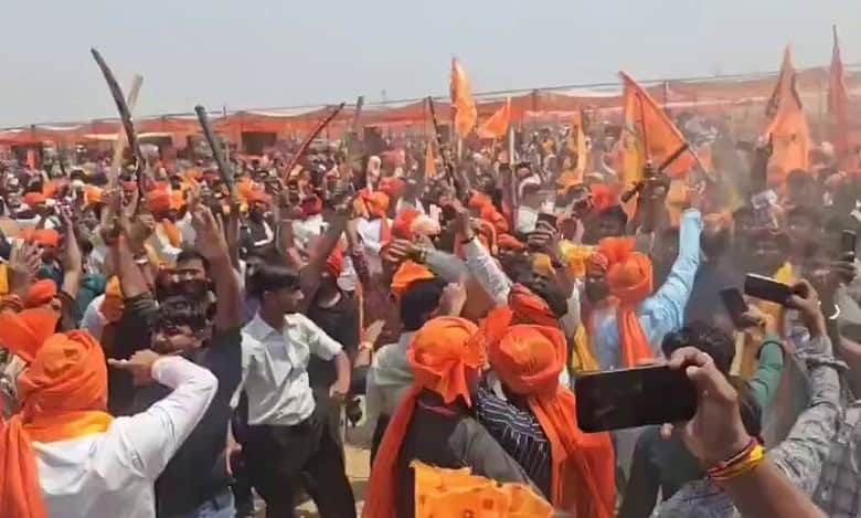 The image displays saffron clad men wielding swords at Karni Sena's "Rakt Swabhiman Sammelan" in Agra, Uttar Pradesh. Date April 12, 2025