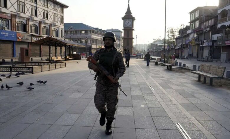 The image displays a picture of a security personnel standing guard at Lal Chowk market