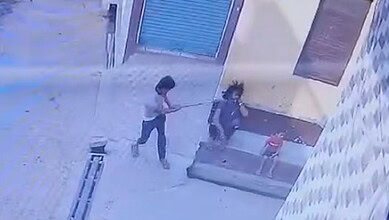 The image displays a man attacking another with a axe. A child is sitting besides them. April 28, 2025