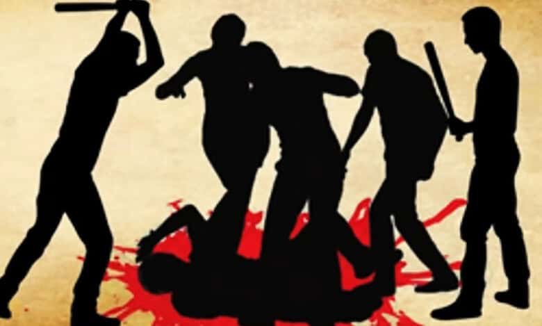 The image displays a representational image of an angry mob attacking with sticks