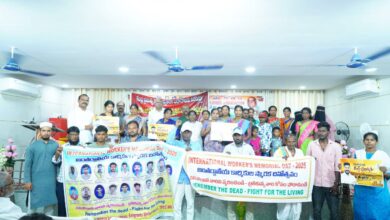 Group photo at Gulf Workers’ Memorial Day event in Nirmal, Telangana, honouring deceased migrant workers with banners and floral tributes.