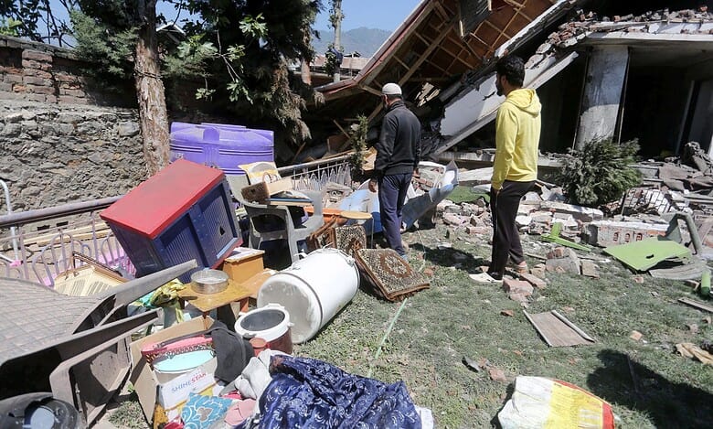 The image displays people near the debris of the house of Lashkar-e-Taiba terrorist Jameel Ahmed, that was demolished amid a crackdown on the terror ecosystem in the aftermath of the Pahalgam terror attack in Bandipora district of J&K on Sunday April 27, 2025