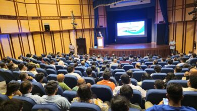 Audience attending an open house for IIT aspirants organised by the Indian Embassy in collaboration with IIT Delhi-Abu Dhabi, held in an auditorium with a speaker on stage.