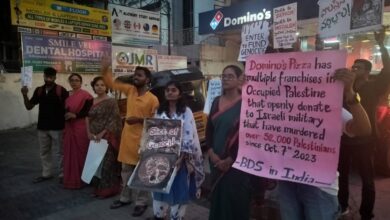 A group of protesters on May 10 stand outside a Domino’s outlet in India, holding signs in solidarity with Palestine. One sign reads, "Slice of Genocide?"