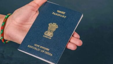Image of an Indian passport in a person's hand.