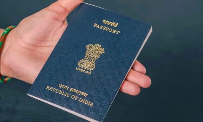 Image of an Indian passport in a person's hand.