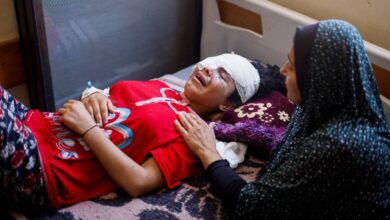Injured Palestinian girl with bandaged eyes lies on a hospital bed in Gaza, comforted by a woman, during Israel’s ongoing assault on the Gaza Strip.