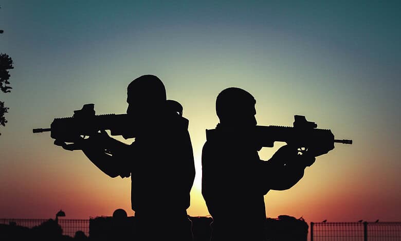 Representational Image of two men facing opposite sites holding guns