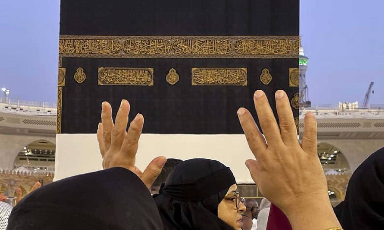 Muslim pilgrims raise their hands in prayer near the Kaaba at the Grand Mosque in Makkah during Haj.
