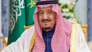 Image of Saudi Arabia’s King Salman bin Abdul Aziz wearing traditional attire with Saudi flag in background.