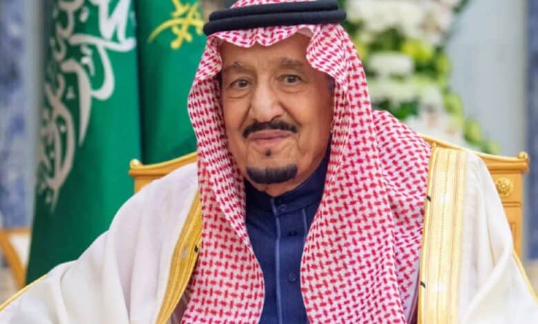 Image of Saudi Arabia’s King Salman bin Abdul Aziz wearing traditional attire with Saudi flag in background.