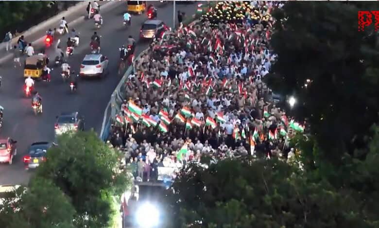 A large crowd gathers at a solidarity rally in Hyderabad on May 7, 2025, supporting the Indian Armed Forces after Operation Sindhoor against Pakistan following the Pahalgam terror attack. People wave Indian flags along a busy road with vehicles, including cars and motorcycles, visible in the background.