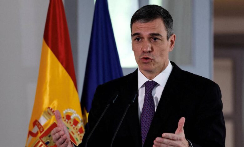 Spanish Prime Minister Pedro Sanchez speaks at a podium with the Spanish and European Union flags in the background.