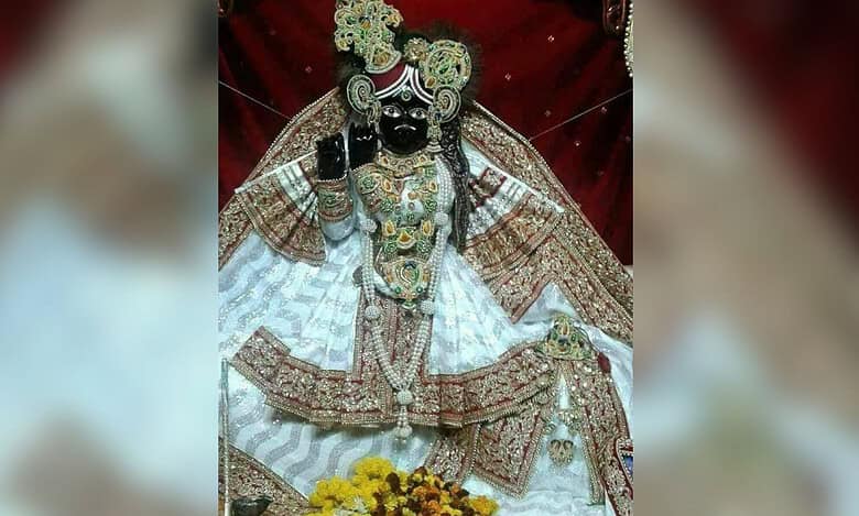 The image displays a picture of Lord Krishna from Vrindavan's Banke Bihari temple
