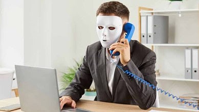 Representationa image of a man with a mask sitting with a laptop for job fraud in Hyderabad story