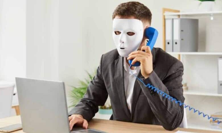 Representationa image of a man with a mask sitting with a laptop for job fraud in Hyderabad story