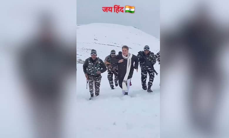The image displays a picture of BJP leader Ravinder Raina marching in the snow surrounded by Indian Army soldiers