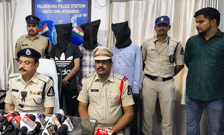 The image displays a picture of three men covered in black cloth and police officers