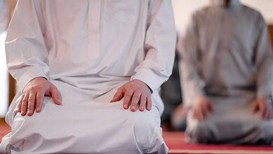 The image displays people offering namaz