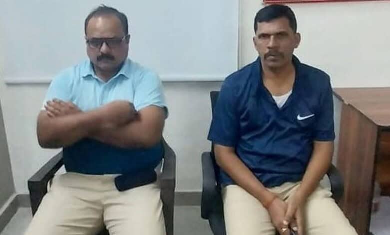 The image displays a picture of two Telangana police officers caught red handed for demanding bribe