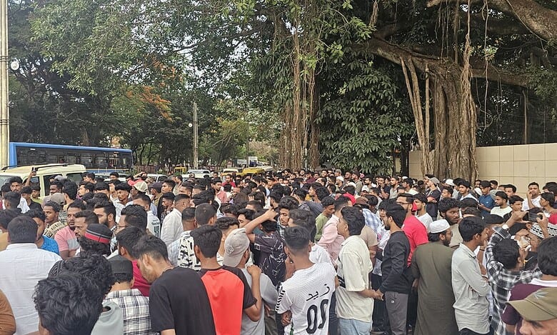 The image displays a picture of a large crowd protesting