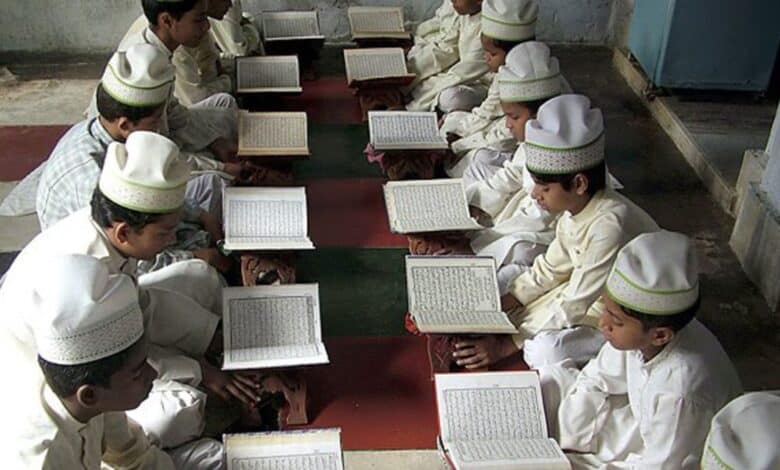 The image shows a madrasa with Muslim boys studying