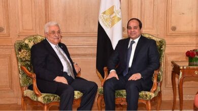 Photo of Palestinian President Mahmoud Abbas and Egyptian President Abdel-Fattah al-Sisi sitting in chairs with flags behind them.